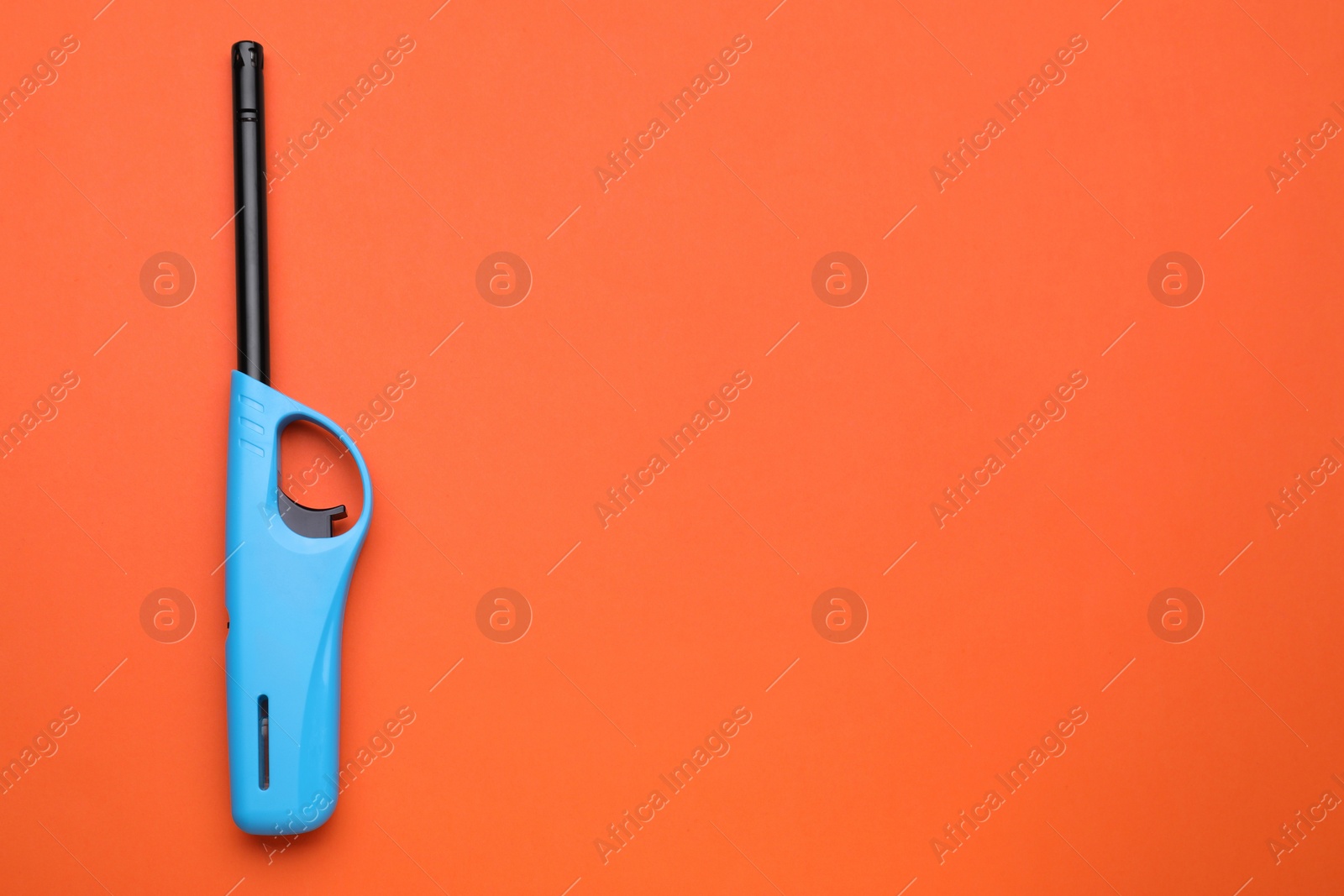 Photo of One gas lighter on orange background, top view. Space for text