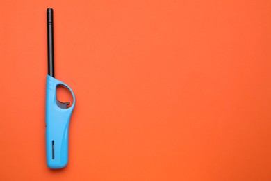 Photo of One gas lighter on orange background, top view. Space for text