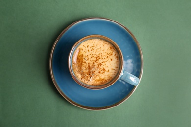 Cup of aromatic hot coffee on color background, top view