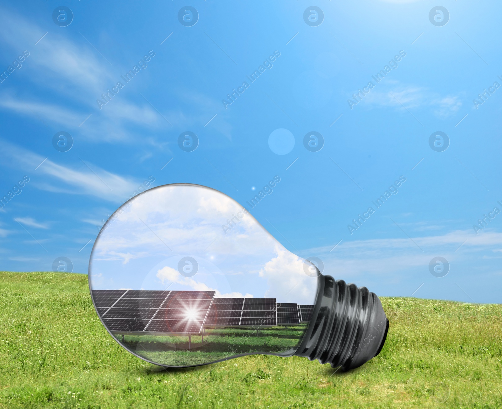 Image of Alternative energy source. Light bulb with solar panels outdoors