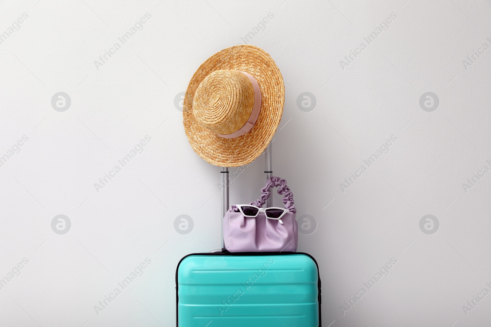 Photo of Suitcase packed for trip and summer accessories on light background