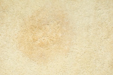 Photo of Wet spot on beige carpet as background, top view