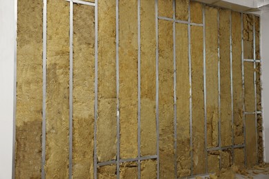 Photo of Wall with metal studs and insulation material indoors