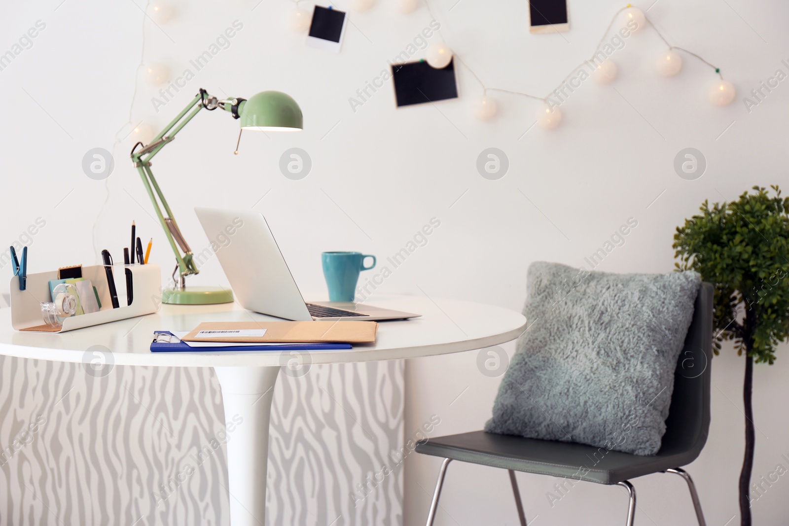 Photo of Stylish workplace with laptop on table in office