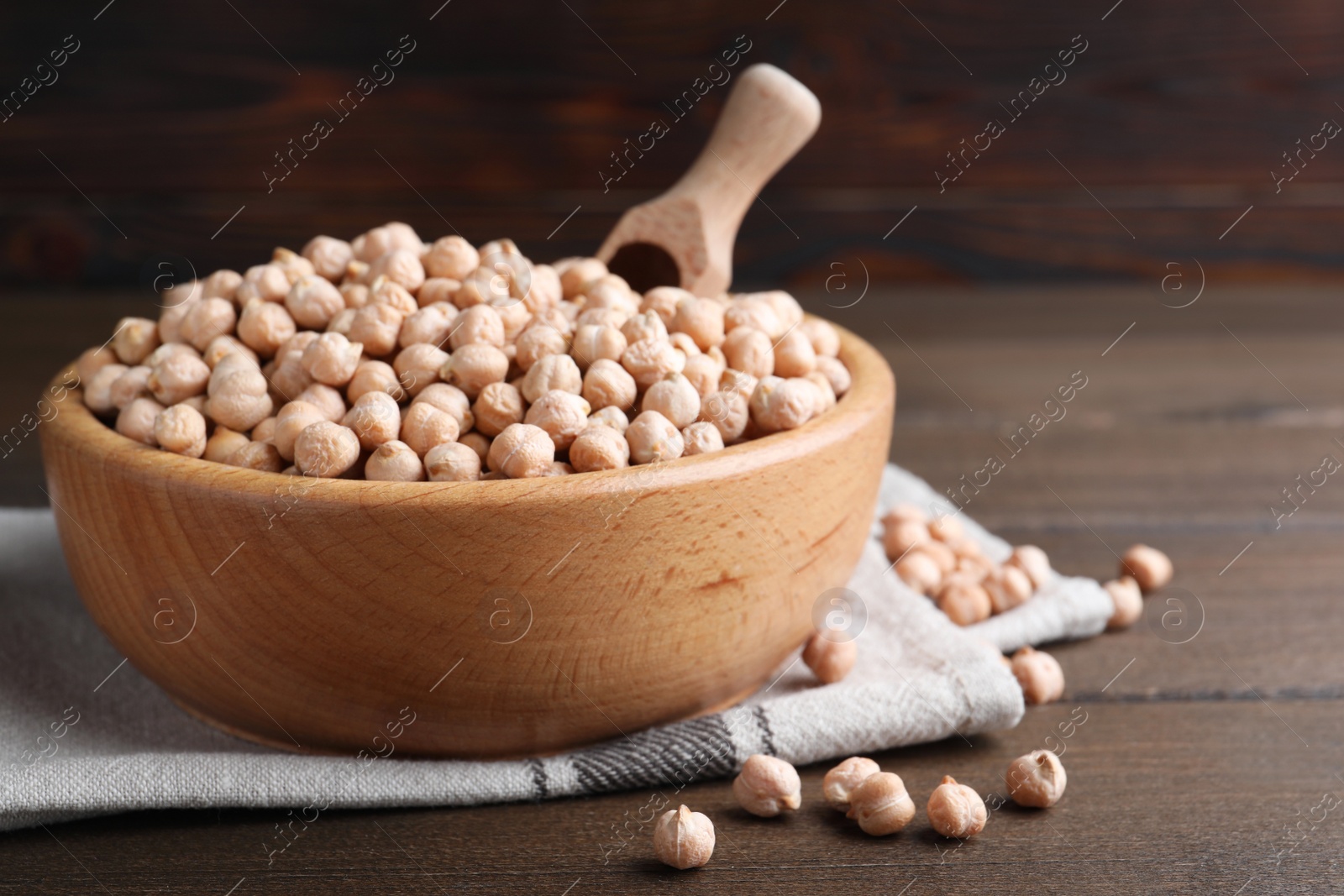 Photo of Chickpeas in bowl on wooden table, space for text