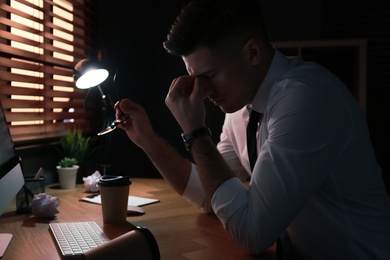 Photo of Businessman stressing out at workplace late in evening