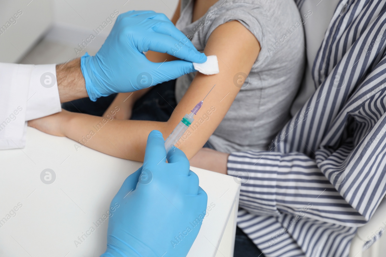 Photo of Children's hepatitis vaccination. Mother with her daughter in clinic. Doctor giving injection to little girl, closeup