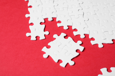 Photo of Blank white puzzle pieces on red background