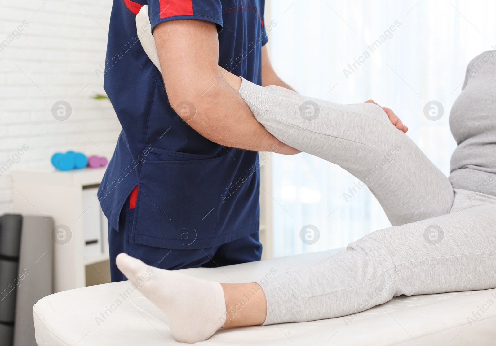 Photo of Physiotherapist working with patient in clinic, closeup. Rehabilitation therapy