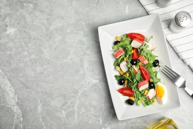 Photo of Tasty crab stick salad served on grey marble table, flat lay. Space for text