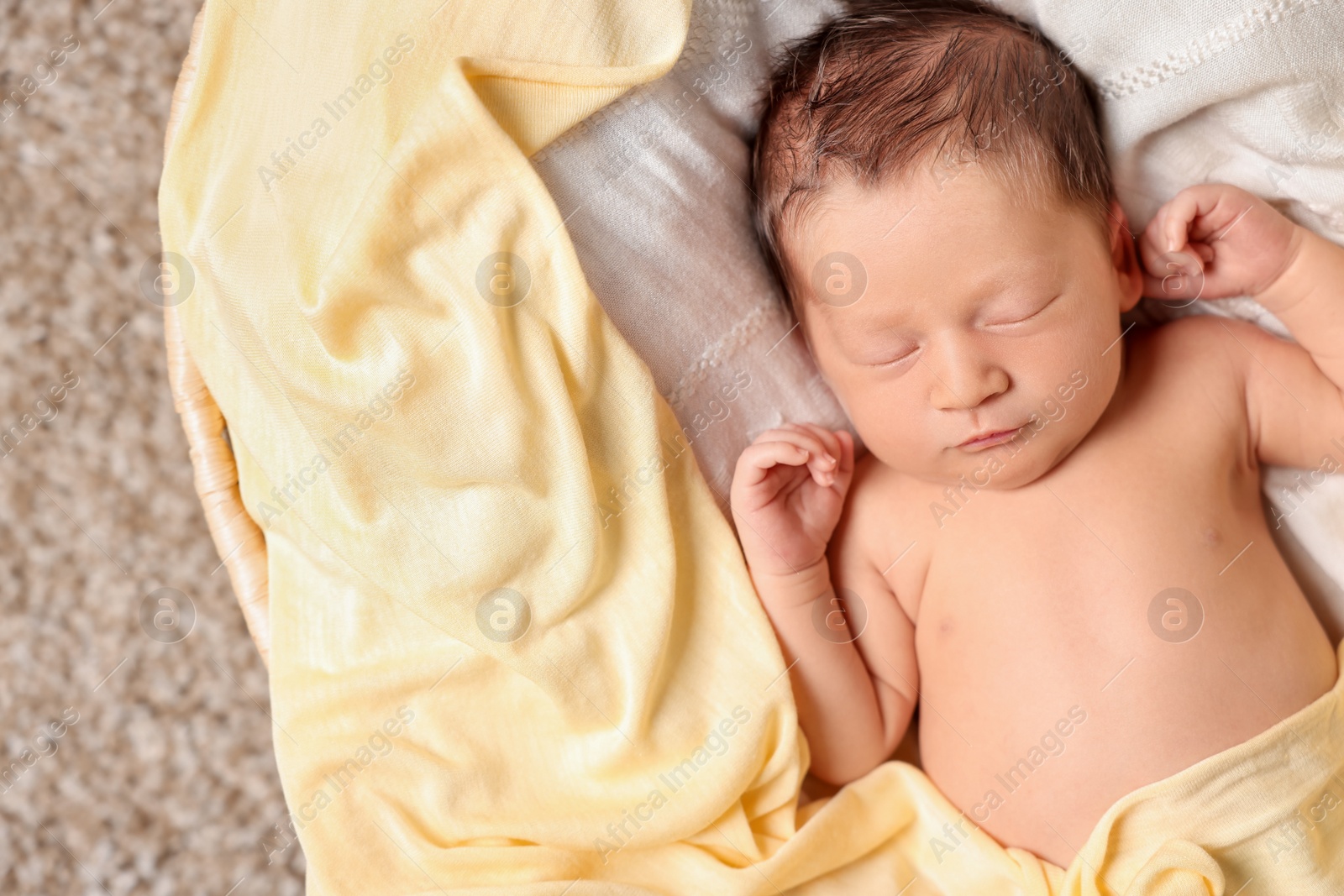 Photo of Cute newborn baby sleeping on white blanket in crib, top view