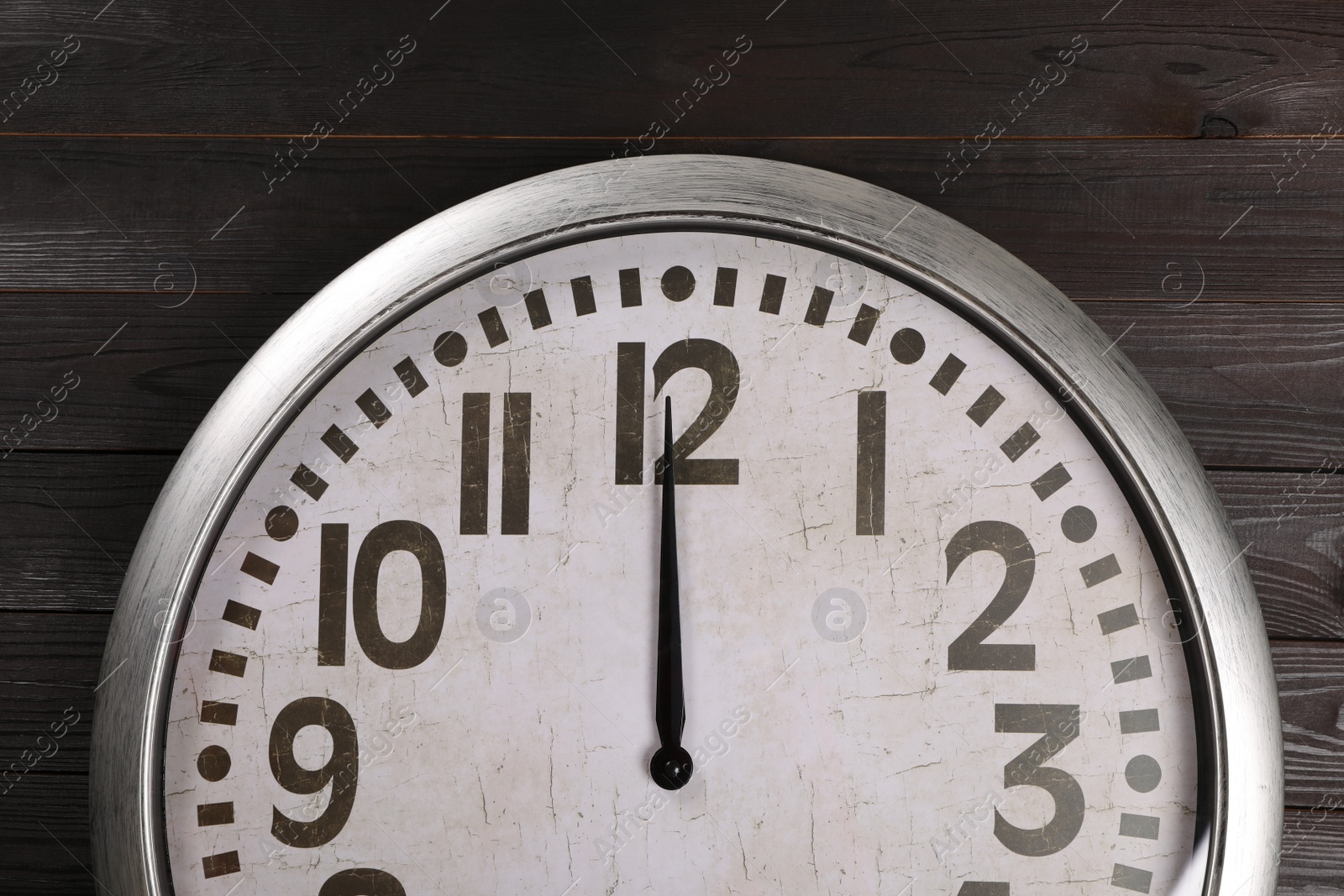 Photo of Stylish analog clock hanging on wooden wall