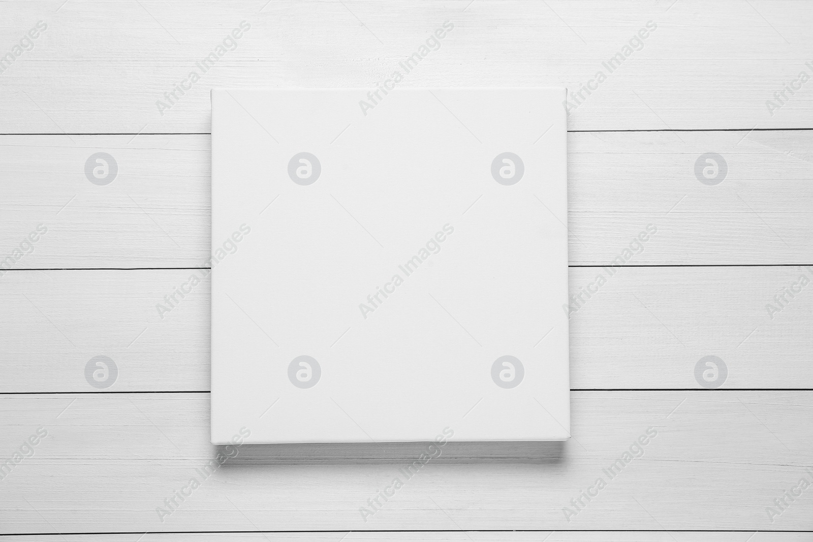 Photo of Blank canvas on white wooden background, top view. Space for design