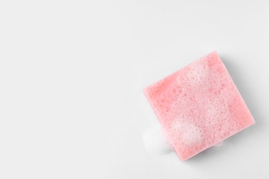 Photo of Soap with fluffy foam on white background, top view