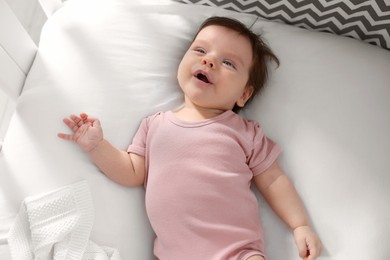 Cute little baby lying on bed, top view