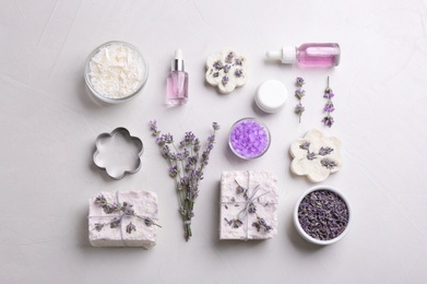 Photo of Flat lay composition with hand made soap bars and lavender flowers on light stone surface