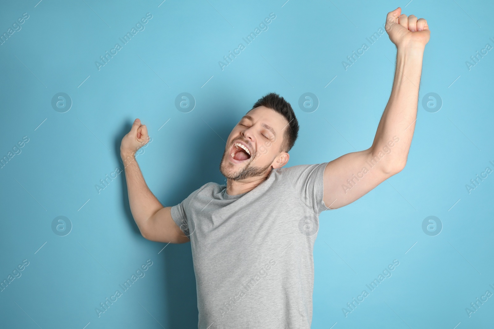 Photo of Portrait of sleepy man yawning on turquoise background