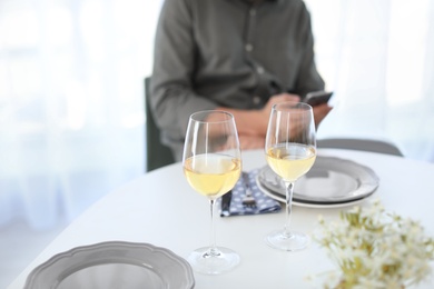 Photo of Glasses of delicious wine and blurred man on background