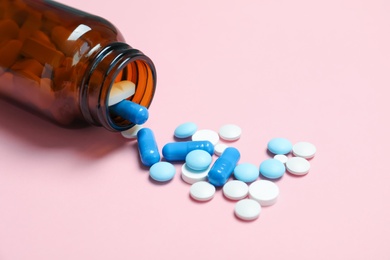 Photo of Bottle with pills on color background