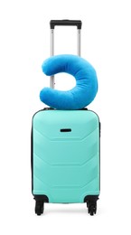 Photo of Soft travel pillow on turquoise suitcase isolated on white