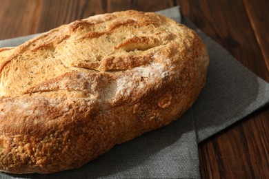 Photo of Freshly baked sourdough bread on wooden table, closeup