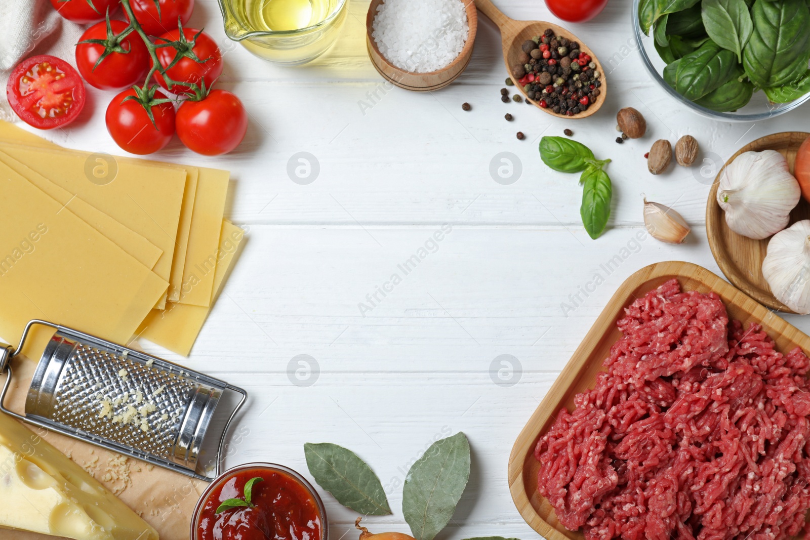 Photo of Frame made of fresh lasagna ingredients on white wooden table, flat lay. Space for text