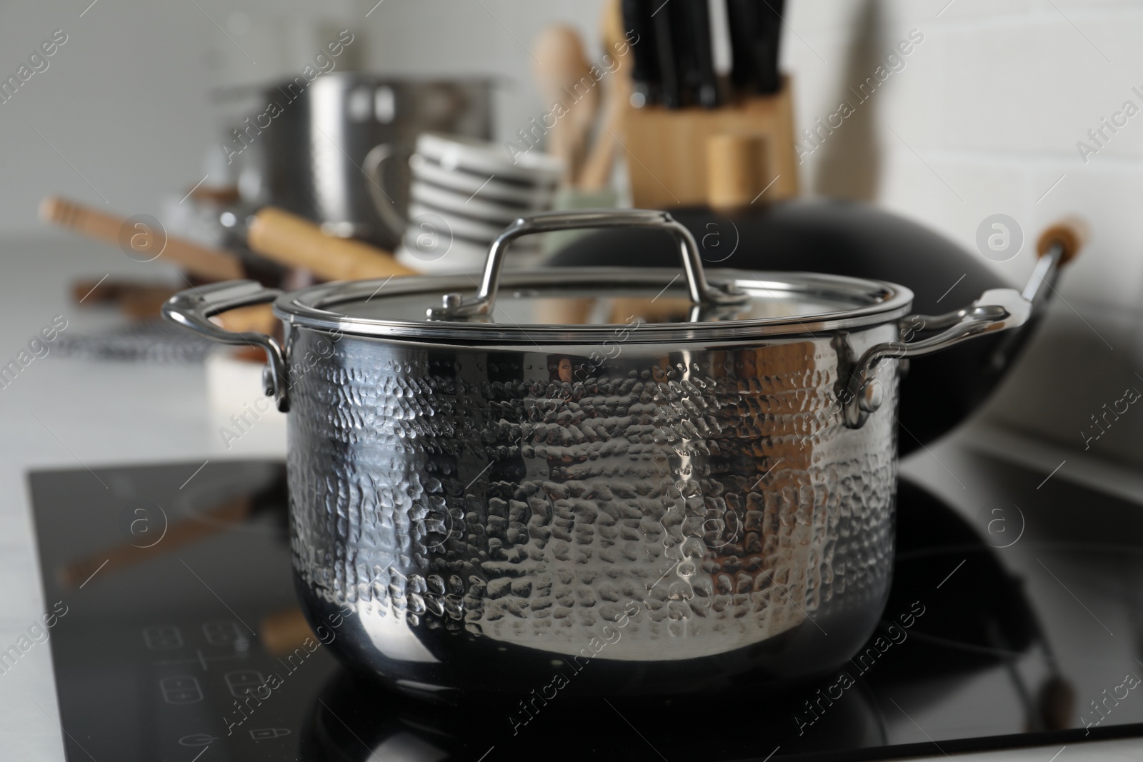 Photo of Metal pot on cooktop in kitchen, closeup. Cooking utensils