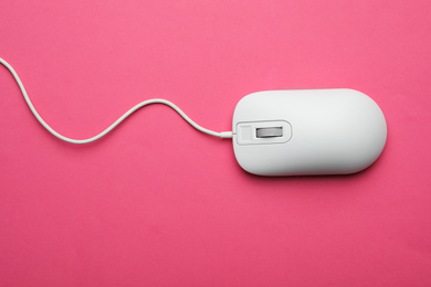 Photo of Wired computer mouse on pink background, top view