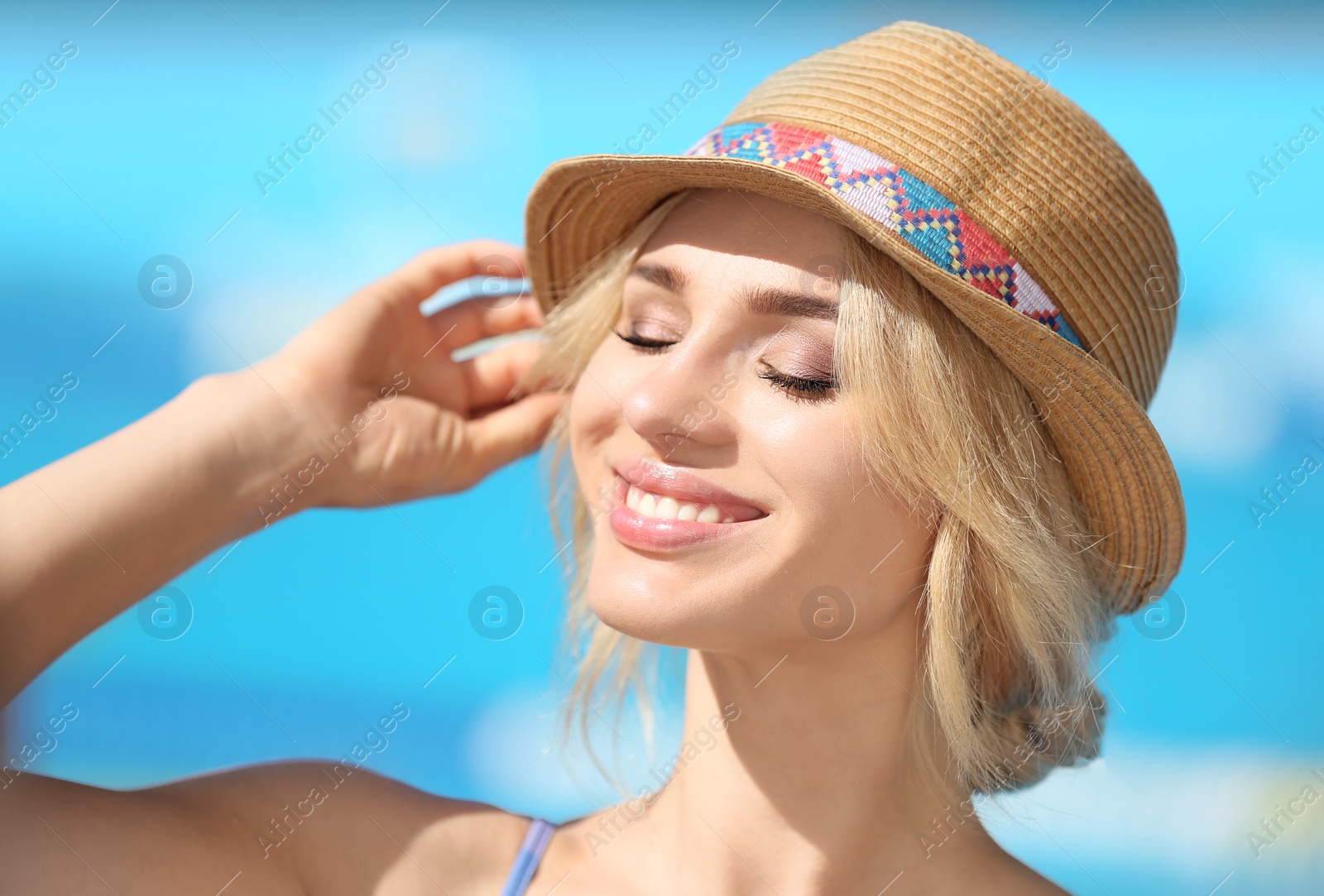 Photo of Sexy young woman with hat near swimming pool on sunny day