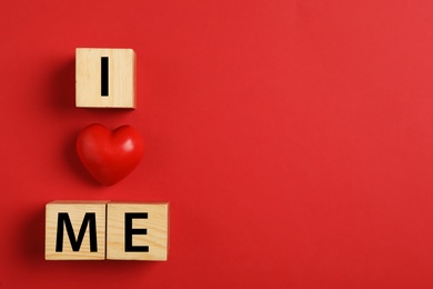 Photo of Phrase I Love Me made with wooden cubes and heart on red background, flat lay. Space for text