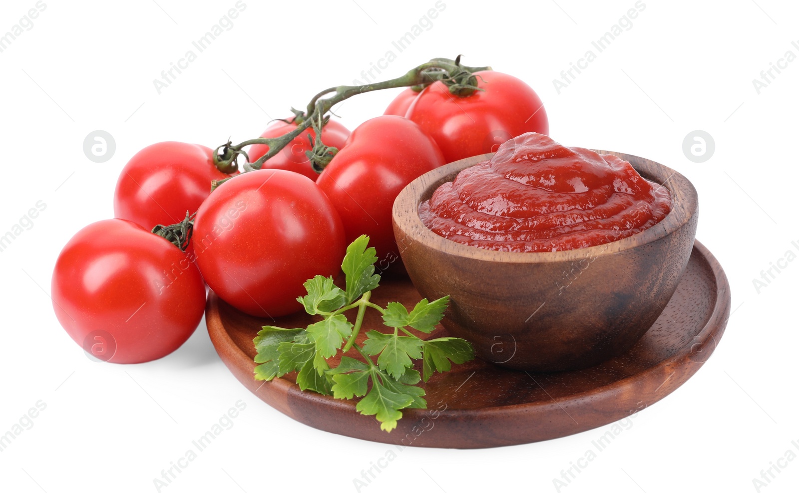 Photo of Organic ketchup in bowl, fresh tomatoes and parsley isolated on white. Tomato sauce