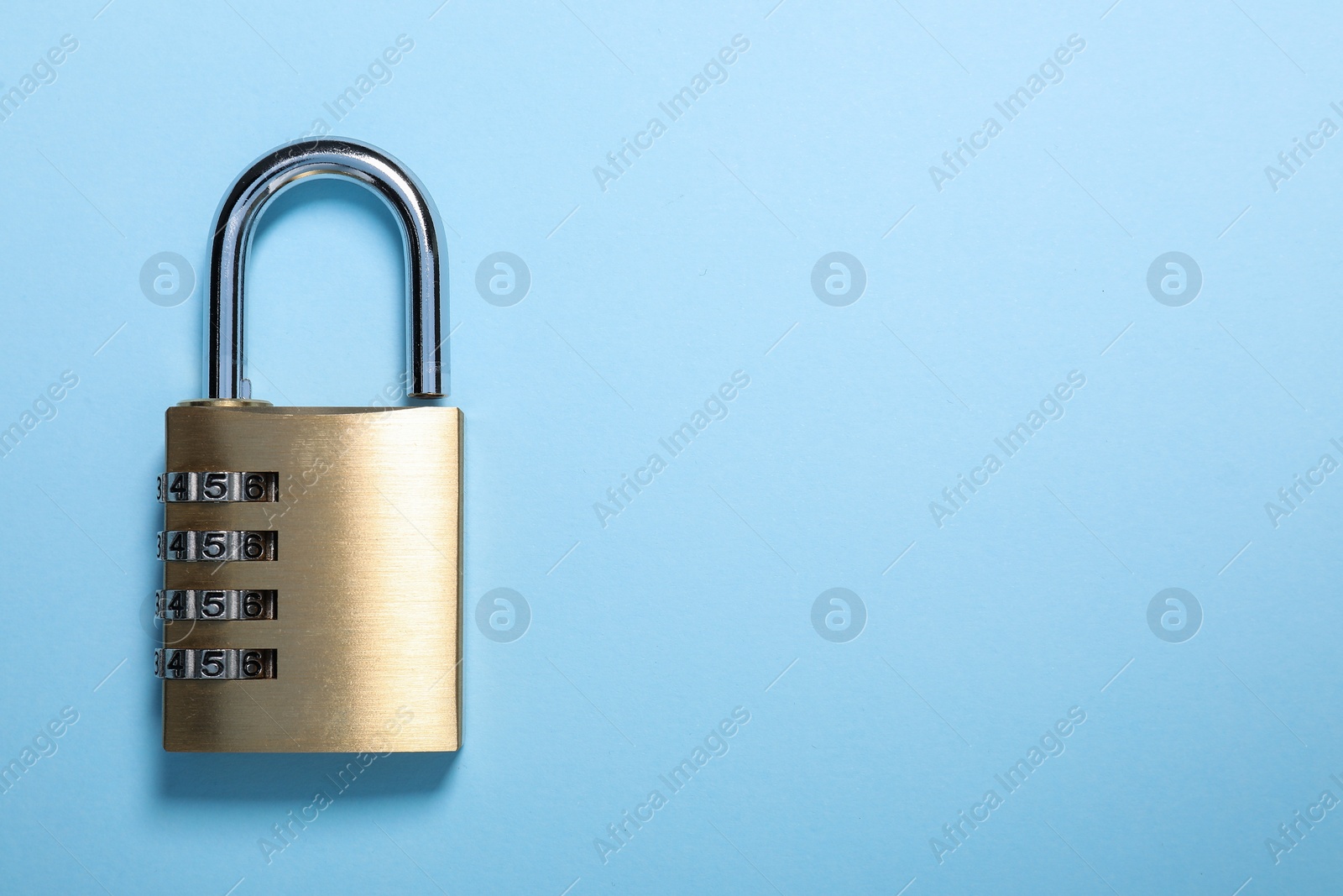Photo of Steel combination padlock on light blue background, top view. Space for text