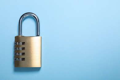 Steel combination padlock on light blue background, top view. Space for text