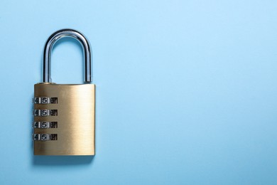 Photo of Steel combination padlock on light blue background, top view. Space for text