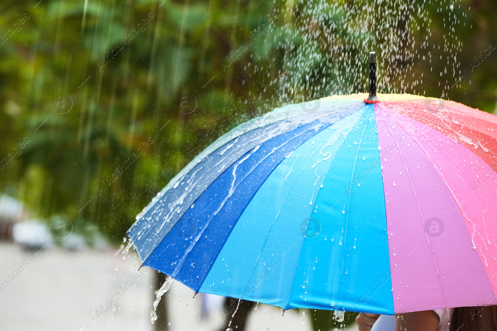 Photo of Person with bright umbrella under rain on street, closeup