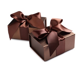 Photo of Brown gift boxes decorated with satin ribbon and bows on white background