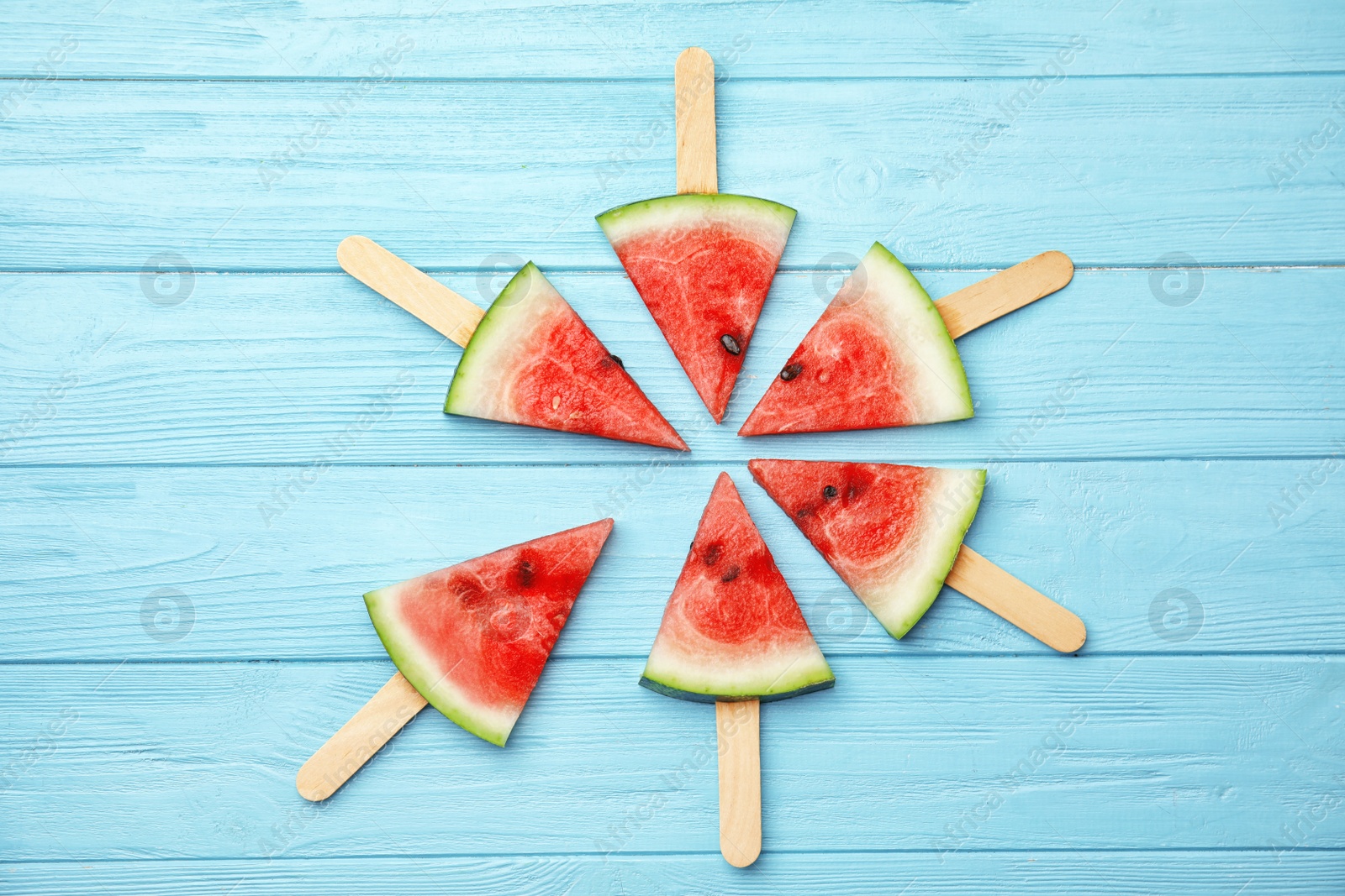 Photo of Flat lay composition with watermelon popsicles on wooden background