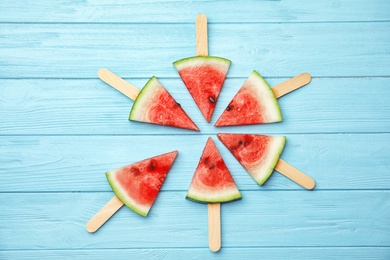 Photo of Flat lay composition with watermelon popsicles on wooden background