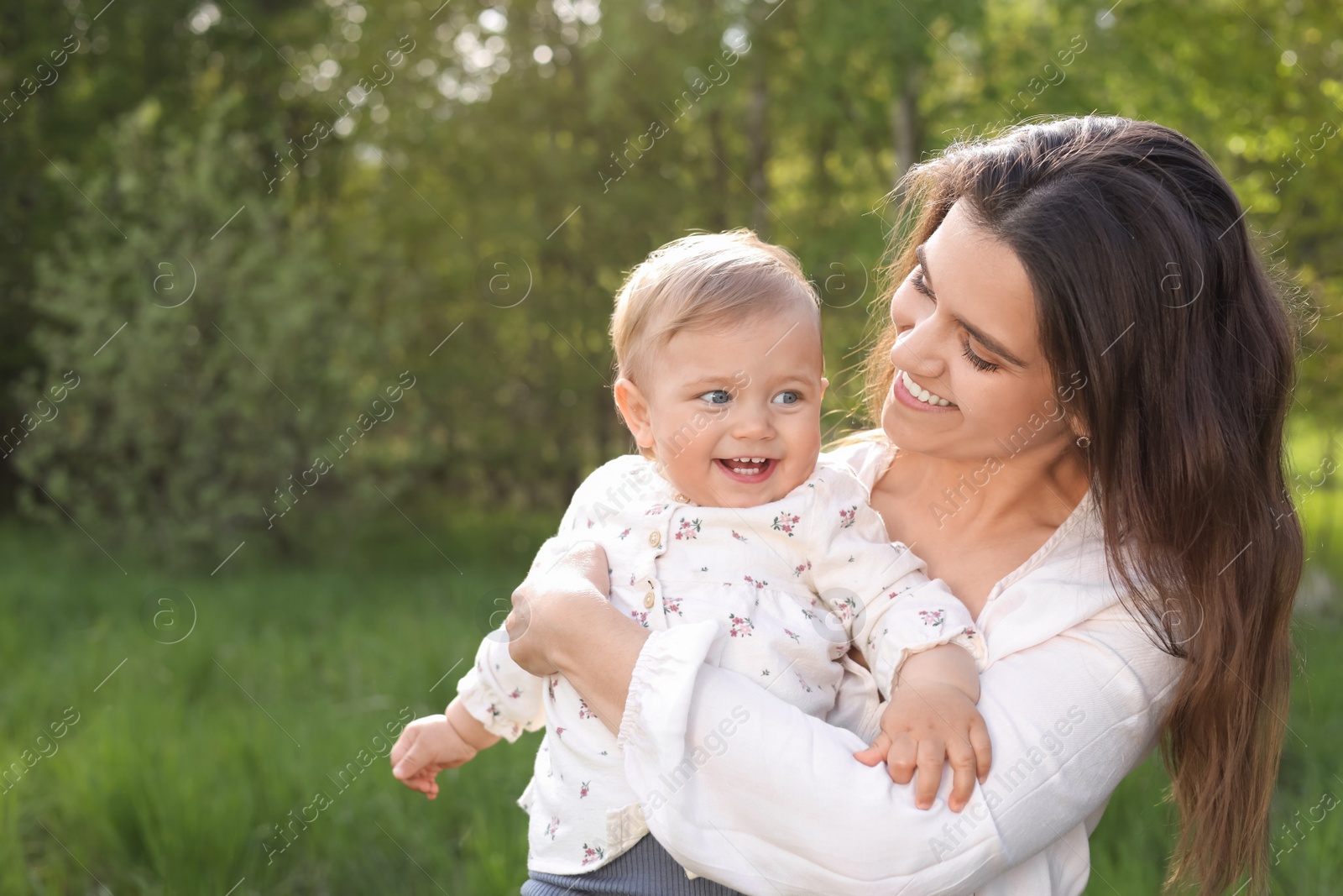 Photo of Happy mother with her cute baby in park on sunny day, space for text