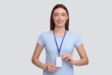 Woman with blank badge on grey background