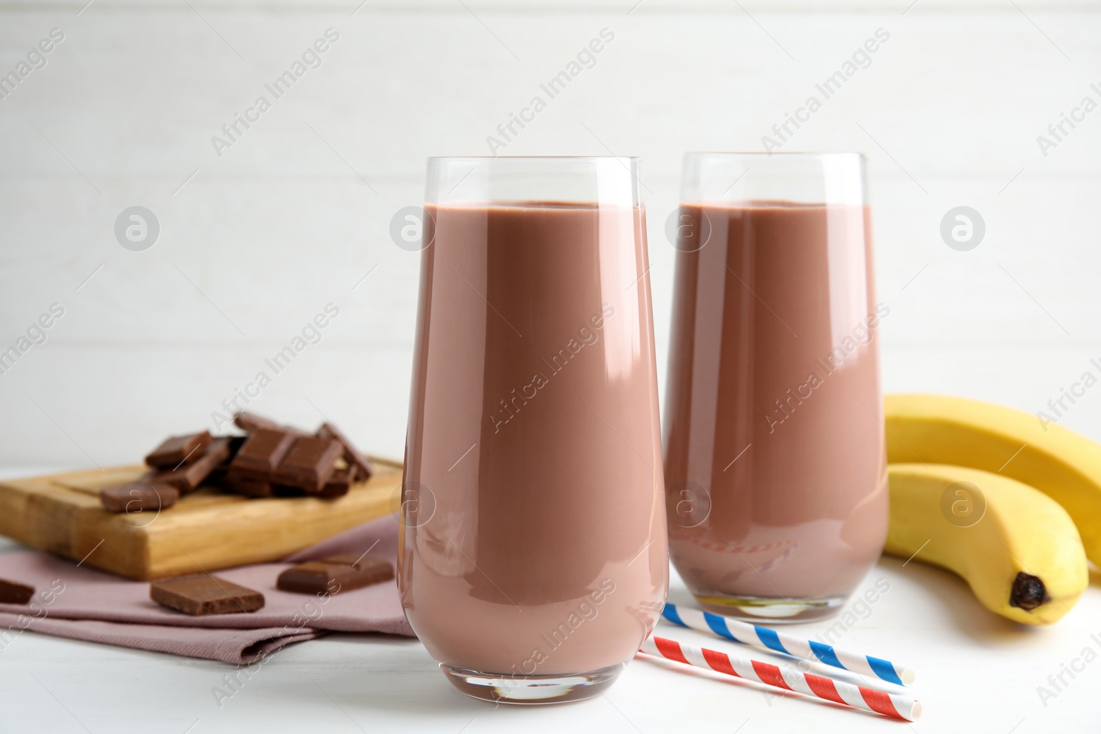 Photo of Fresh yummy chocolate milk on white wooden table