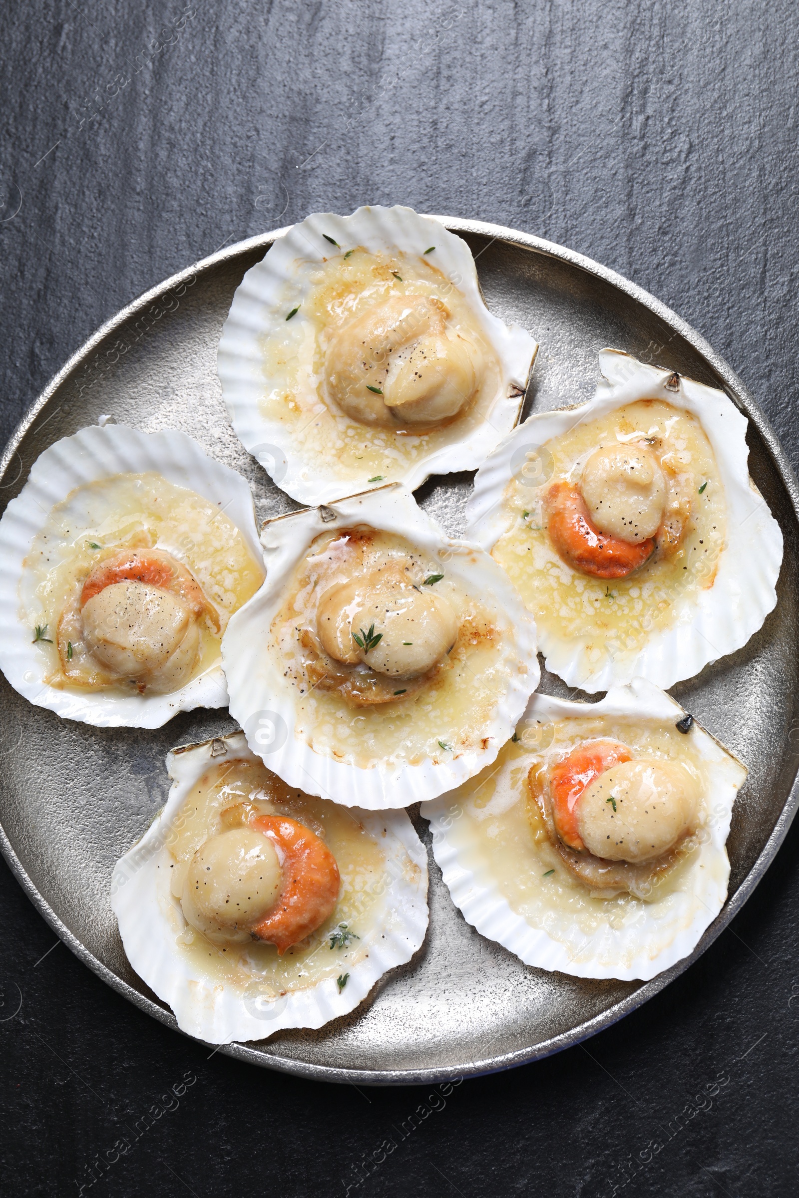 Photo of Fried scallops in shells on black table, top view