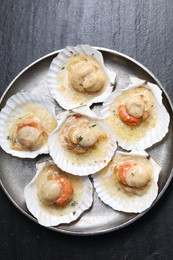 Fried scallops in shells on black table, top view