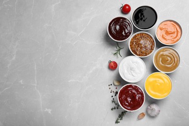 Photo of Many different sauces on light grey table, flat lay. Space for text