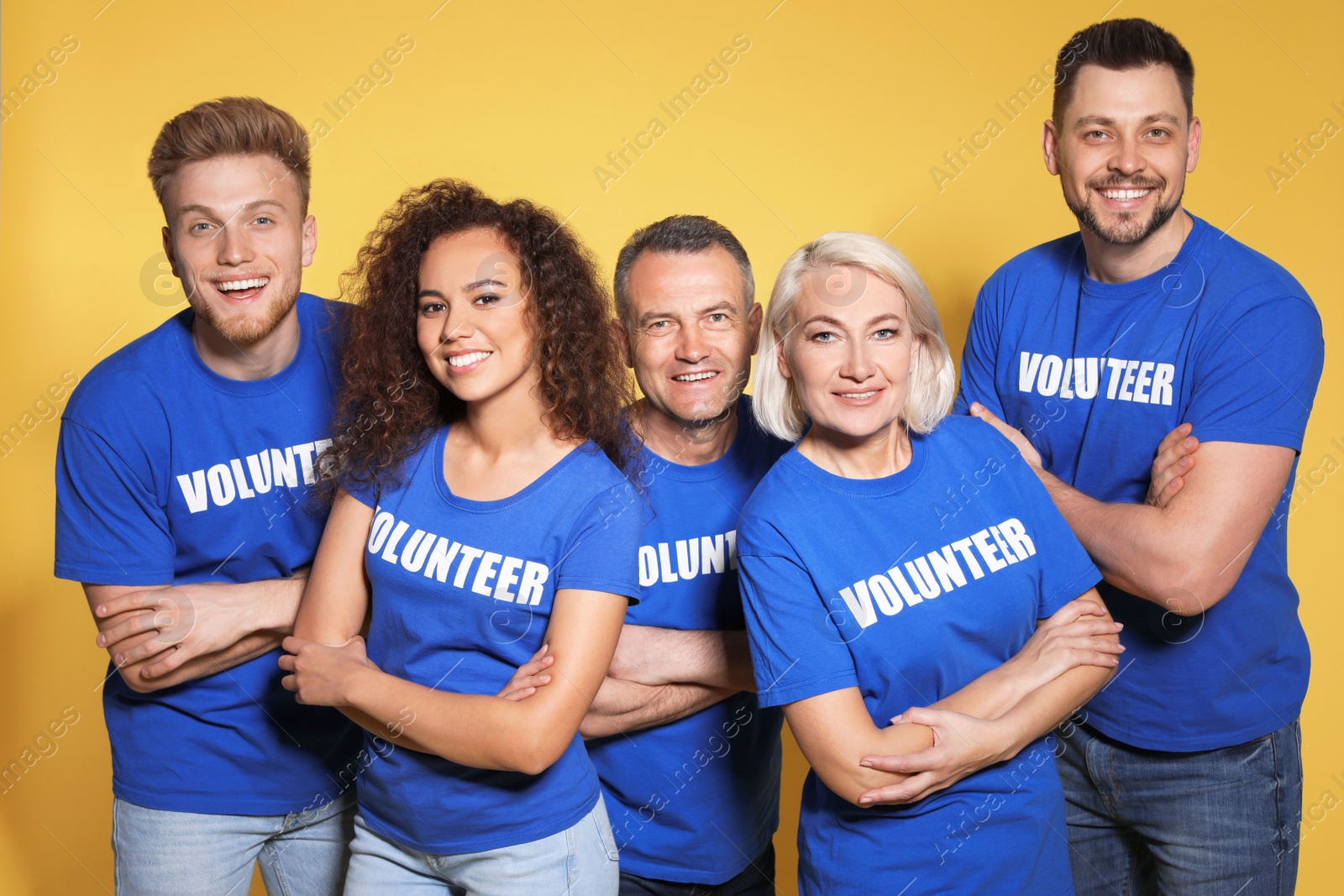 Photo of Team of volunteers in uniform on yellow background