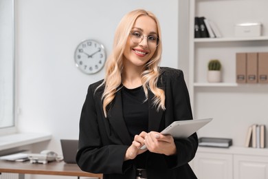 Portrait of happy secretary with tablet in office