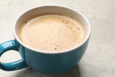 Photo of Cup of aromatic coffee on light grey table, closeup