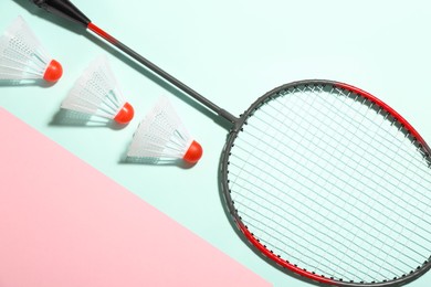 Badminton racket and shuttlecocks on color background, flat lay