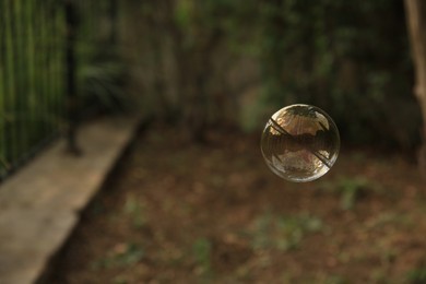 Photo of Beautiful soap bubble floating outdoors. Space for text