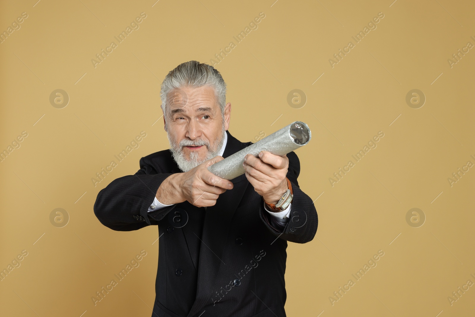Photo of Man with party popper on beige background